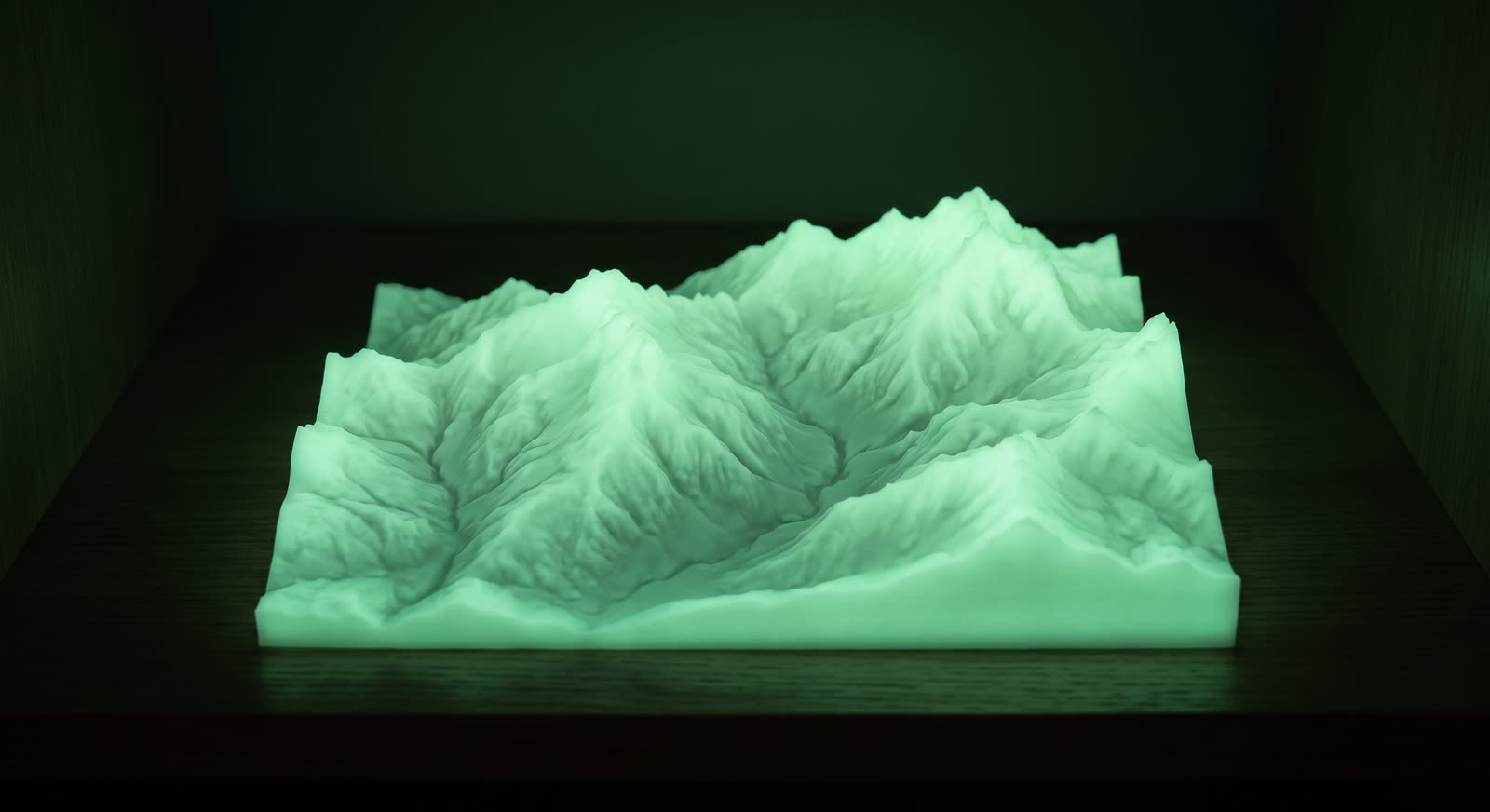 Relief alpin imprimé en 3D en finition phosphorescente, luisant en vert pâle dans une pièce sombre